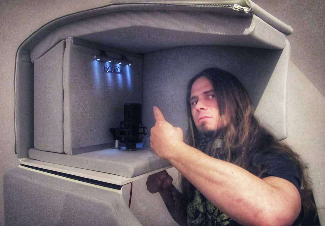 man with long hair recording vocals inside the ISOVOX 2 White portable vocal booth