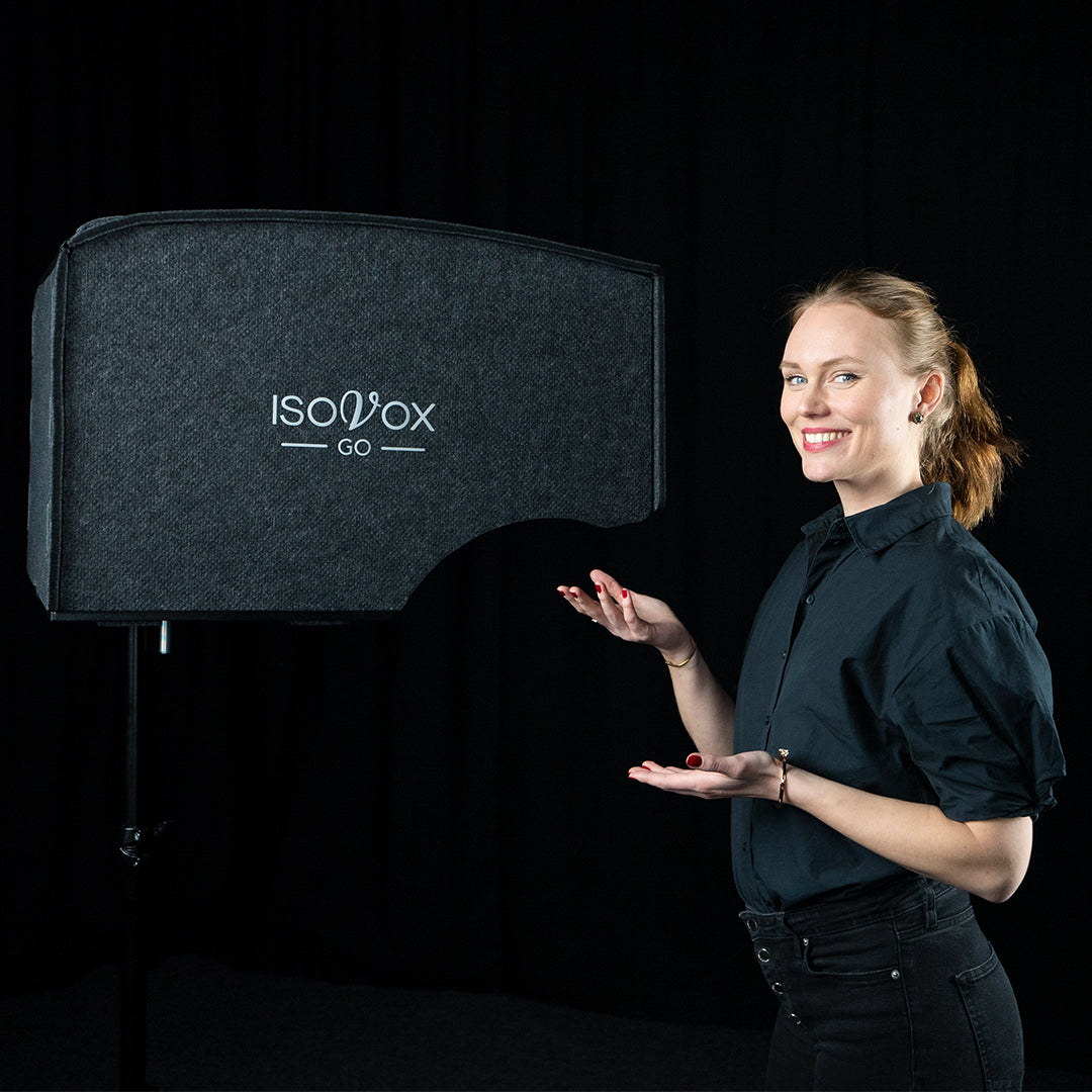 person standing next to the ISOVOX GO home recording booth